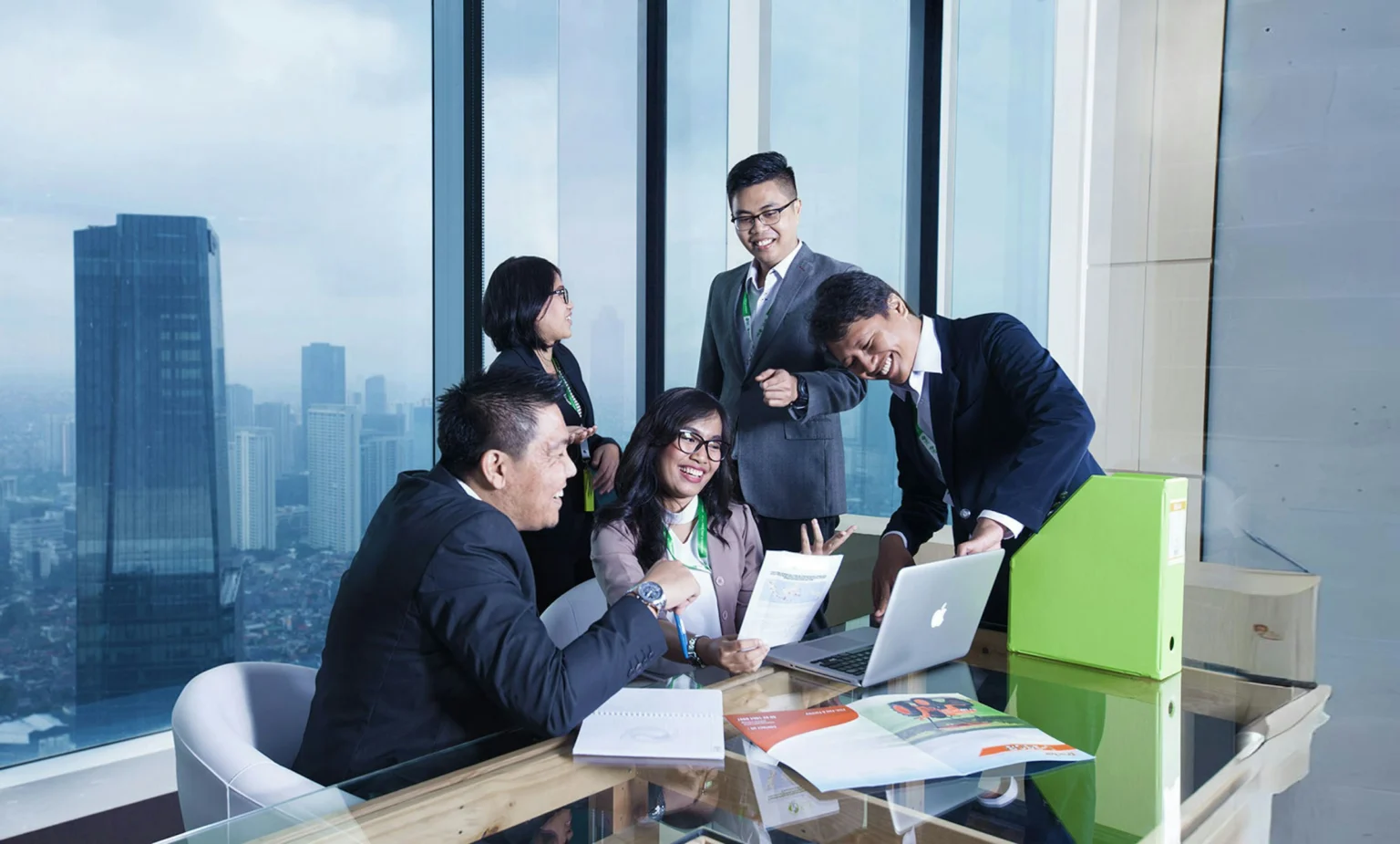 A business team working together beside a window overlooking the city